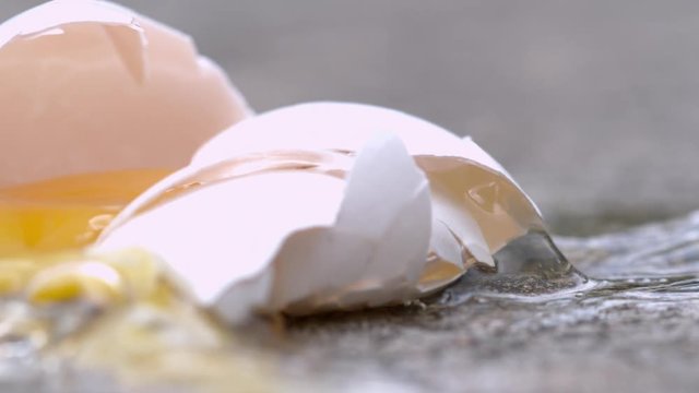 Cracked egg yolk on street slow motion
