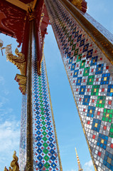 The columns of the traditional Thai temple are decorated with multicolored mirror mosaics.