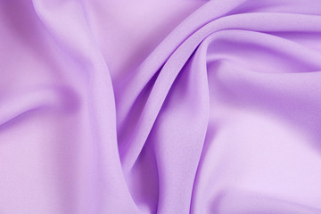 The texture of the satin fabric of lilac color for the background