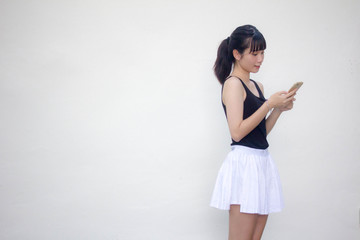 Portrait of thai adult beautiful girl black shirt white skirt using her smart phone