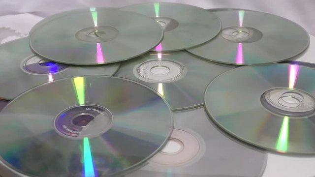The base cds and dvds moving in round motion on white