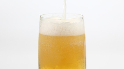 pouring beer into a glass on white background