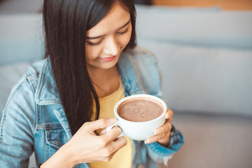 Attractive Asian woman drinking coffee.cheerful girl drinking coffee or tea in morning