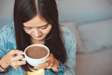 Attractive Asian woman drinking coffee.cheerful girl drinking coffee or tea in morning