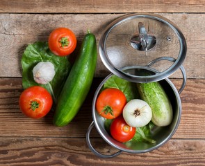 top view of cooking pot with vegetables. cucumbers with tomatoes.