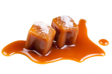 Melted caramel candies and caramel sauce with a salt  isolated on a white background. Close up.