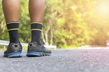 Man runner feet on road in Park workout wellness soft focus and focus close up on shoe