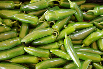 Close up full frame view of green peppers displayed for sale at a market stand