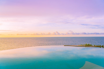 Fototapeta na wymiar Beautiful outdoor infinity swimming pool in hotel resort with sea ocean view and white cloud blue sky