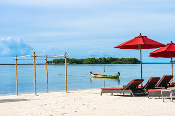 Beautiful outdoor tropical beach sea ocean with umbrella chair and lounge deck around there on white cloud blue sky