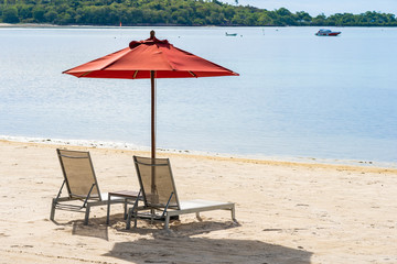 Beautiful outdoor tropical beach sea ocean with umbrella chair and lounge deck around there on white cloud blue sky
