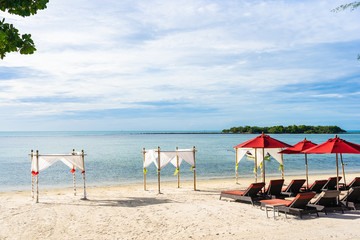 Fototapeta premium Beautiful outdoor tropical beach sea ocean with umbrella chair and lounge deck around there on white cloud blue sky