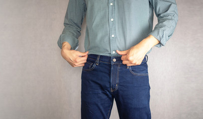 Man tucking shirt in jeans close up