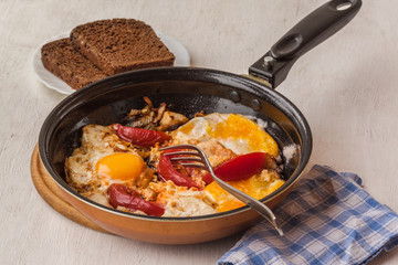 Fried eggs with onions and tomatoes.