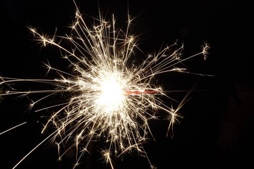 sparkler on black background during 4th of July celebrations.