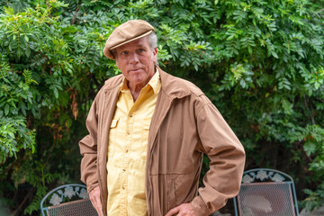 Portrait of good looking senior man in his 60s outdoors wearing a Scottish hat