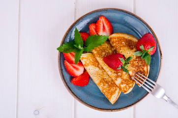 Hot sweet pancakes with fresh strawberries. Photo