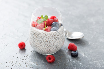 Healthy vanilla chia pudding in a glass with fresh raspberries .