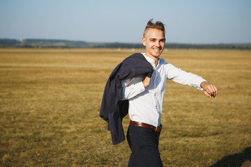A guy in a suit walks on the field.