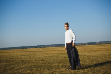 A guy in a suit walks on the field.