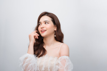 Fototapeta premium Beautiful woman smiling. Young Female touching Her Skin. Portrait on White Background. Perfect Skin. Beauty Face.