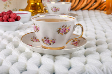 Close up of beautiful vintage pink cup with tea on the table