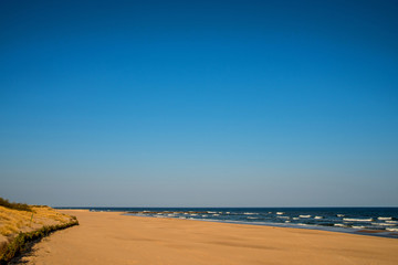 Fototapeta na wymiar lonesome beach of the Baltic Sea in Poland with blue sky