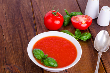 Cold tomato soup on wooden surface. Photo