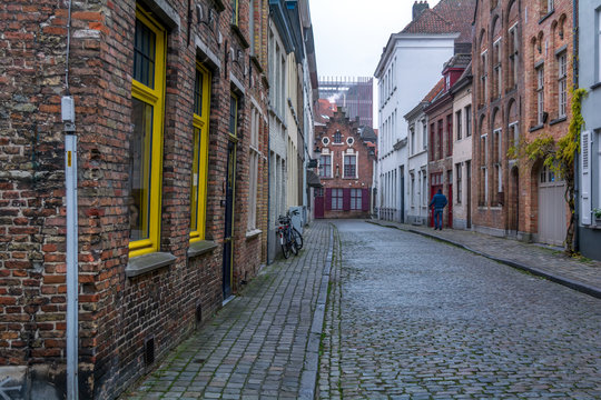 Picturesque old street of Bruges with traditional medieval houses, cobbled road and bicycle. Cityscape of Bruges streets.