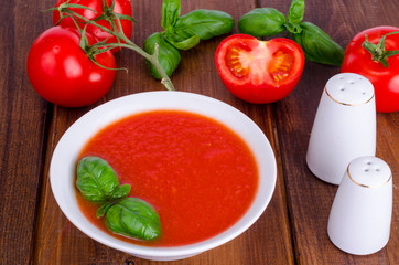 Cold tomato soup on wooden surface. Photo