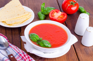 Cold tomato soup on wooden surface. Photo