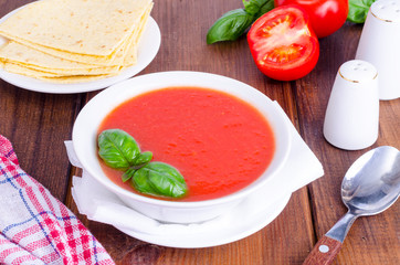 Cold tomato soup on wooden surface. Photo