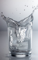 spray water in a glass on a gray background