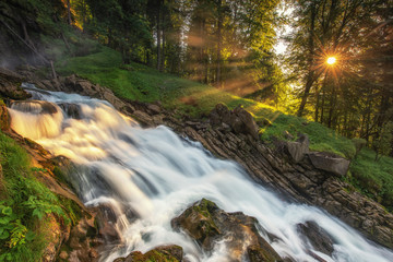 mountain river in the forest with sunbeams