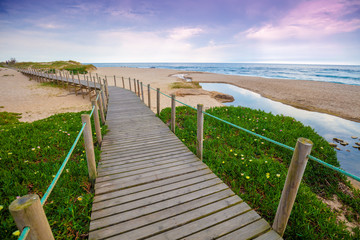 The wooden footpath on the sandy seashore on a sunny day. Porto, Portugal, Europe