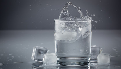 Pouring water into glass on blue background close up