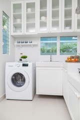 Interior of modern kitchen with washing machine. Laundry day