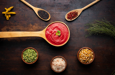 A red soup top view with spices and ingredients