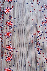 Fototapeta premium UK flag on wooden background with confetti copy space. the concept of independence day, memory and sorrow