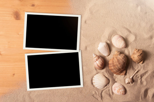 Empty photo cards lying on a sea sand. Sunny summer background.