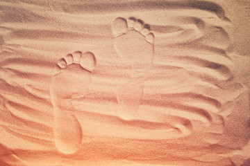 Fototapeta na wymiar Human footprints on dry sand in sunny summer day. Go forward. Top view.