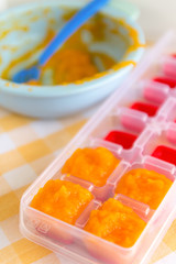 Preparing baby food, homemade. Healthy boiled or steamed crinkle sliced fresh carrots  preparing to be made as an ice cube in ice cube tray. Healthy food kids concept. Selective focus. 