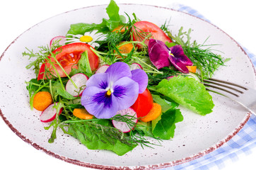 Vegetable salad with edible flowers on white background