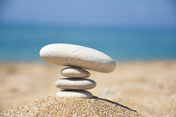 Balanced stone pyramid on sand on beach. Zen rock, concept of balance and harmony