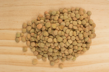 Pile lentil on wooden table, top view.