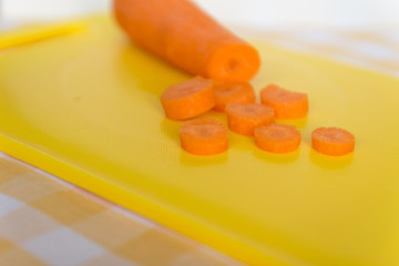 Fresh peeled carrot and cut pieces on cutting board..