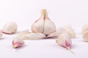 head of young garlic and cloves on a gray background