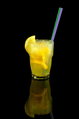 yellow cocktail with lemon slice, summer refreshing lemonade with straw, over black background