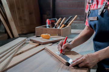 Carpenter working with equipment on wooden table in carpentry shop. woman works in a carpentry shop.