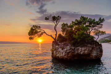 Fototapeta na wymiar Brela Stone (Kamen Brela) - a symbol of Brela, a popular natural attraction in Croatia. Beautiful sunset view of Brela Stone, Punta Rata beach, Makarska riviera of Dalmatia, Croatia